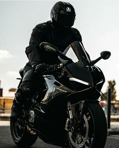 a man riding on the back of a black motorcycle