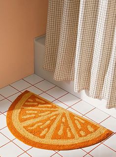 an orange rug is on the floor next to a shower curtain