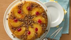 a pineapple upside down cake sitting on top of a white plate next to a fork