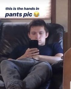 a man sitting on a couch looking at his cell phone with the caption, this is the hands in pants pic