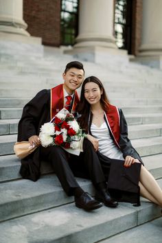 a man and woman are sitting on the steps with their graduation gowns over their shoulders