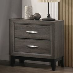 a night stand with two drawers and a lamp