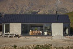 a house with a table and chairs in front of mountains