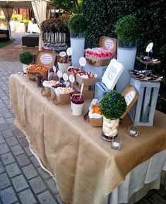 a table topped with lots of desserts on top of a brown cloth covered table