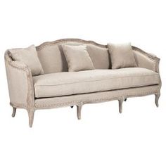 a white couch with pillows on it and some wood trimming around the armrests