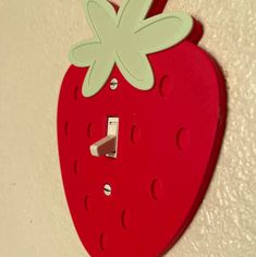 a red strawberry shaped light switch cover