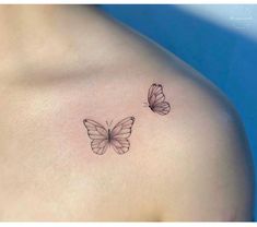 two small butterflies on the back of a woman's shoulder, one is black and white