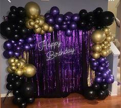 purple and gold balloon arch with happy birthday sign