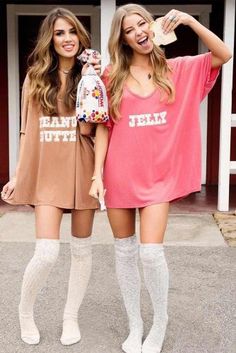 two young women standing next to each other in front of a building wearing matching outfits