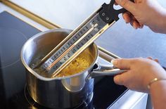 a person is using a large kitchen knife to cut food into small bowls on the stove