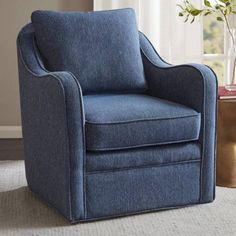 a blue chair sitting on top of a rug next to a vase filled with flowers