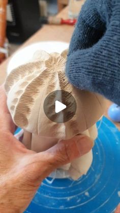 a person is making an ornament out of clay and paper maching it