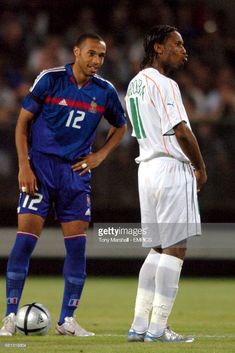 two soccer players standing next to each other on the field