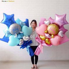 a woman is holding balloons in her hands