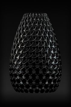 a black vase that is made out of metal mesh and has holes in the middle