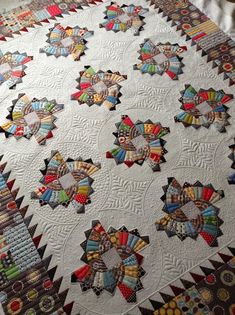 a quilted table topper with many different designs on it