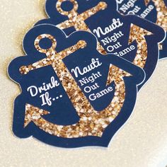 three blue and gold glittered coasters with an anchor on one side and the words drink, nuts, night out game on the other