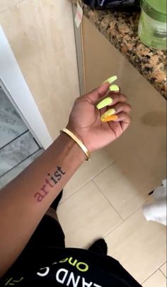 a person with yellow nail polish on their left hand and the word just married written on her right wrist