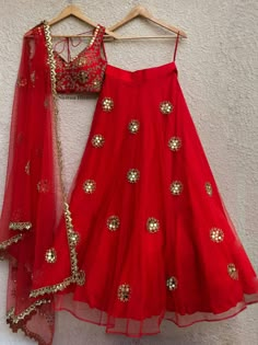 This red mirror lehenga is covered with embroidered butis.  It is paired with an intricately hand embellished blouse.  The outfit is completed with a tulle dupatta with butis and cutwork border. Mirror Lehenga, Mirror Work Lehenga, Lehnga Dress, Bridal Lehenga Red, Half Saree Designs, Net Lehenga, Red Mirror, Red Lehenga, Indian Lehenga