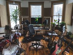 a room filled with lots of musical instruments and plants in it's windowsill