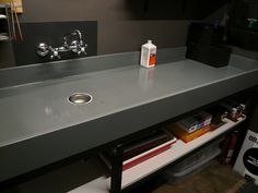 a bathroom sink sitting under a faucet next to a shelf filled with books