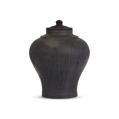 a black vase sitting on top of a white surface