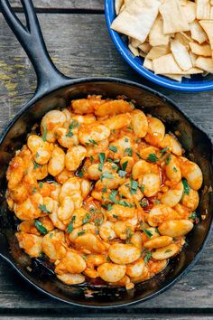 spanish style butter bean dip camping appetizer in a cast iron skillet with text overlay