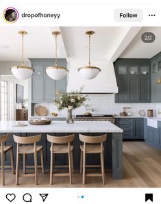 a kitchen with blue cabinets and wooden stools in front of an island counter top