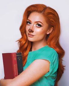 a woman with long red hair holding a book