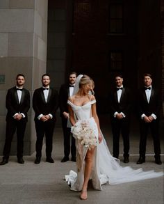 a bride and groom standing in front of their wedding party