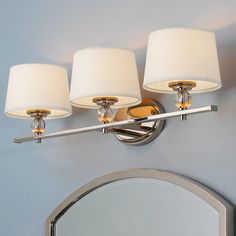 a bathroom light with four lamps on it and a mirror in front of the wall