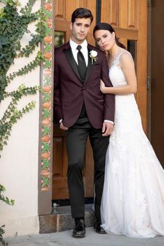 a bride and groom standing in front of a door