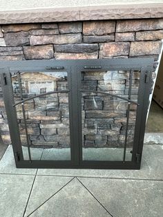 a fire place sitting on top of a sidewalk next to a stone wall and door