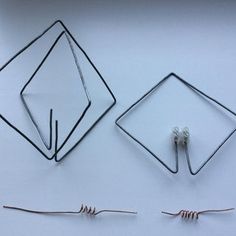 two pieces of wire sitting next to each other on a white surface with one piece missing