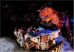 people are riding in an amusement vehicle that looks like a dinosaur