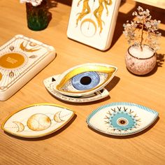 four decorative plates sitting on top of a wooden table