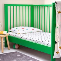 a child's bed with green slats and white sheets