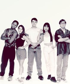 four people are standing in front of a white background with their arms crossed and looking at the camera