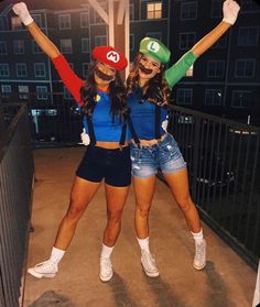 two women dressed up in mario and luigi bros costumes posing for the camera at night