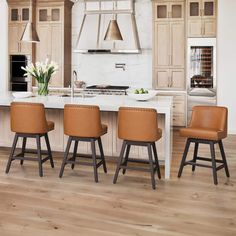 a kitchen with wooden flooring and white counter tops topped with brown leather stools