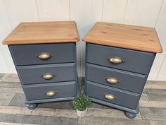 two grey dressers with wooden tops and brass handles, one has a potted plant