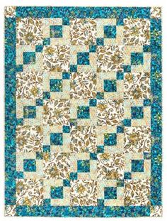 a blue and white quilt with an intricate design on the center, in front of a white background