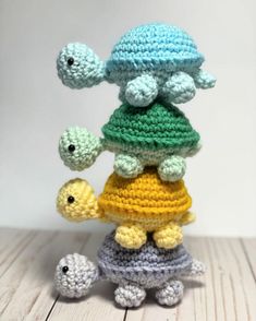 a small crocheted turtle is standing on top of a smaller tortoise