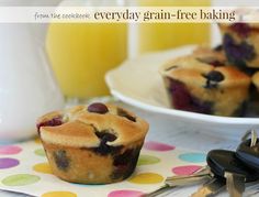 blueberry muffins on a polka dot napkin with a glass of orange juice