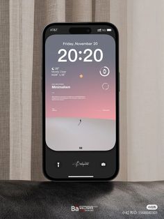an iphone with the time displayed on it's screen, next to a curtain