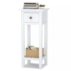 a white end table with a basket and books on the top, against a white background