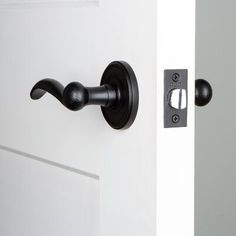 an open door with a black handle on it and a white door in the background