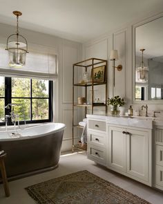 a bathroom with a tub, sink and large window