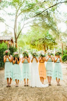 a group of women standing next to each other in front of trees and flowers on their heads