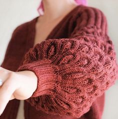 a woman is wearing a red sweater and pointing at something